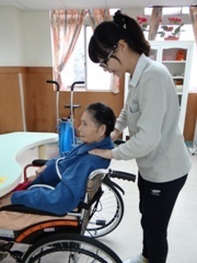 同學帶著笑容為住民按摩圖片